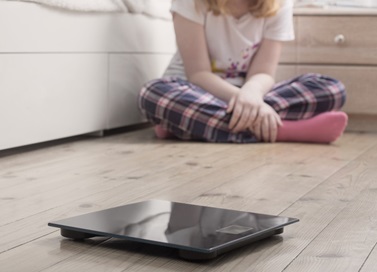 Child sitting on floor with body scales visible in foreground